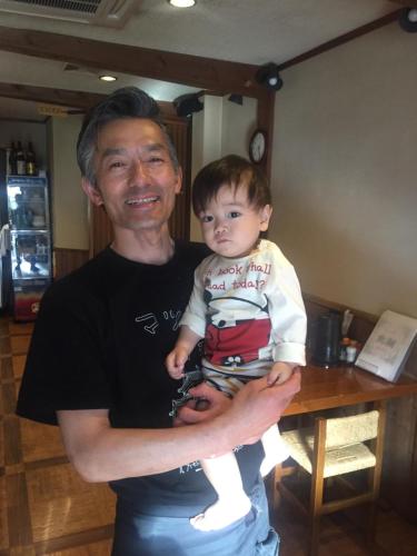 a man holding a baby in his arms at Guest house daisho oshiro asobi in Matsue