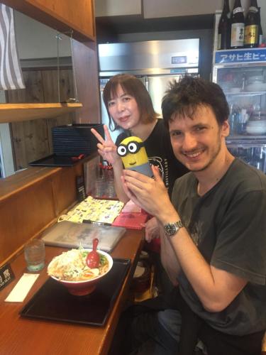 a man and a woman posing for a picture in a restaurant at Guest house daisho oshiro asobi in Matsue