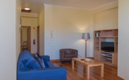 a living room with a blue couch and a table at Apartments Madeira Santa Maria in Funchal