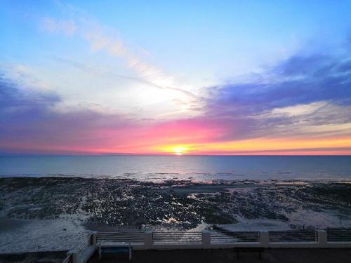 a sunset over the ocean with the sun setting at Superbe vue mer... Au calme in Ault