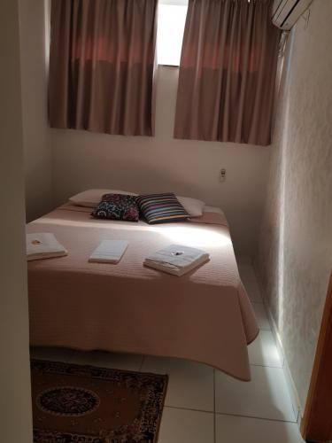 a bed with two pillows on it in a room at Pousada Cantinho DelMar in Olímpia