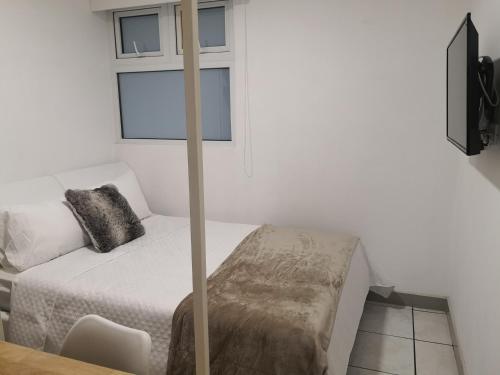 a small bedroom with a bed with a window at Apartments and Rooms Distecon in Guatemala