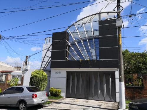 a car parked in front of a house with a garage at Apartments and Rooms Distecon in Guatemala