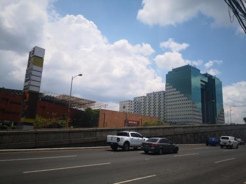 a highway with cars and buildings in a city at Apartments and Rooms Distecon in Guatemala
