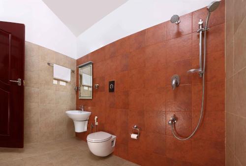 uma casa de banho com um WC, um chuveiro e um lavatório. em Arayal Resort-A Unit of Sharoy Resort em Tariyod