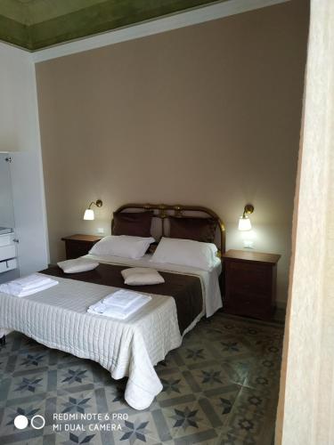 a bedroom with two beds and two night stands at Le Suite del Teatro cucinino privato in Taranto