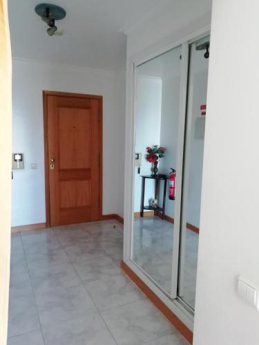 a hallway with a mirror and a door at Porto Seguro in Portimão