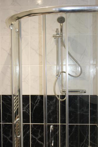 a shower in a bathroom with black and white tile at Park Lane Heights - Self Catering - Guesthouse Style - Family and Double Rooms in Workington