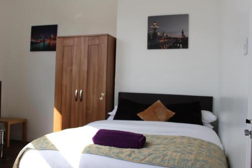 a bedroom with a large bed and a wooden cabinet at Park Lane Heights - Self Catering - Guesthouse Style - Family and Double Rooms in Workington