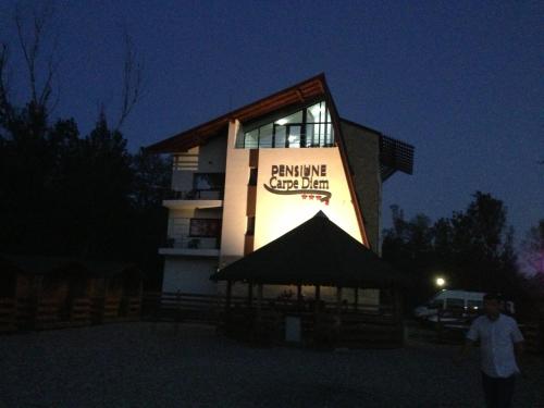 a building with a tent in front of it at night at Pensiunea Carpe Diem in Râmnicu Vâlcea