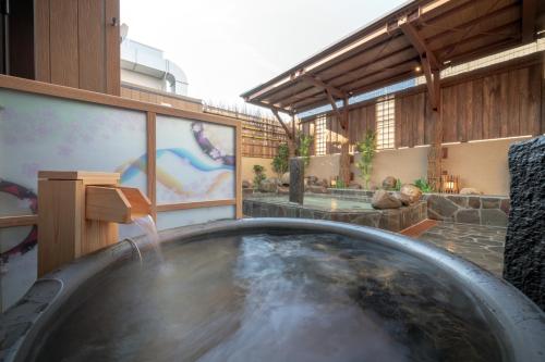 a hot tub with a waterfall in a building at Dormy Inn Morioka in Morioka