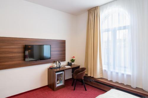 a hotel room with a desk and a television at Bohemia Inn Hotel in Turnov