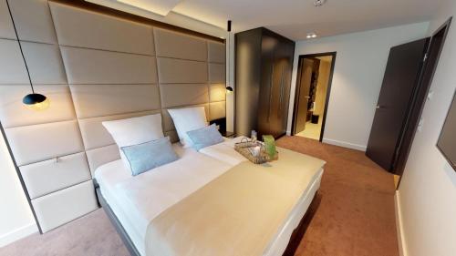 sypialnia z dużym białym łóżkiem z niebieskimi poduszkami w obiekcie White Pearl Apartment 2.05 w mieście Timmendorfer Strand