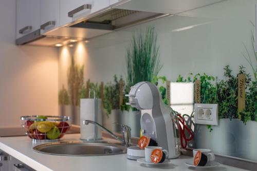 a kitchen counter with a mixer on a sink at Apartments Steel Residence -Tesla Test Drive and 120 kW Supercharger in Timişoara