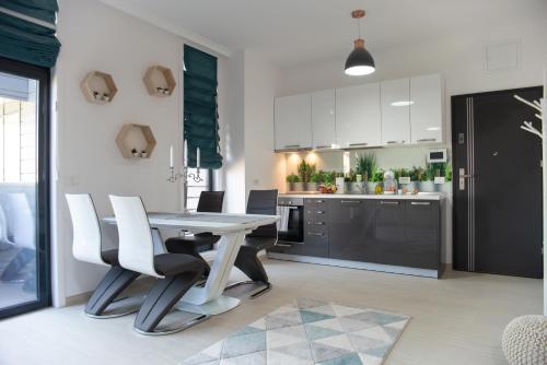 a kitchen and dining room with a table and chairs at Apartments Steel Residence -Tesla Test Drive and 120 kW Supercharger in Timişoara