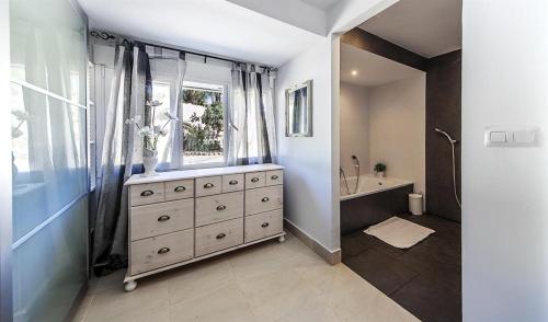 baño con tocador, ventana y lavabo en Andrago, en Moraira