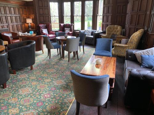 a living room with couches and tables and chairs at The Old Lodge in Malton