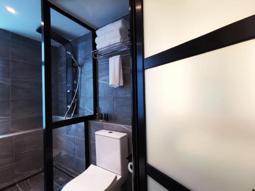 a bathroom with a toilet and a shower at Oikos Poshtel in Kota Kinabalu