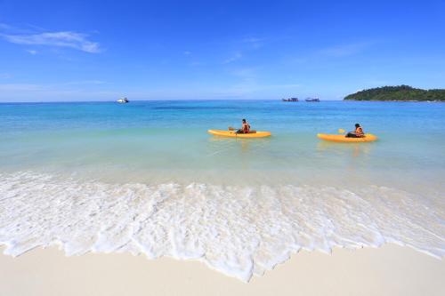 two people in yellow kayaks in the water on the beach at Bundhaya Villas in Ko Lipe