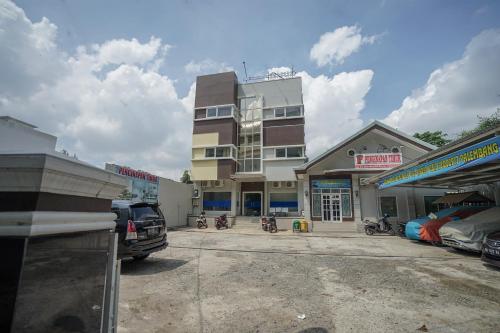 a building in the middle of a parking lot at RedDoorz Plus near Palembang Airport 3 in Palembang