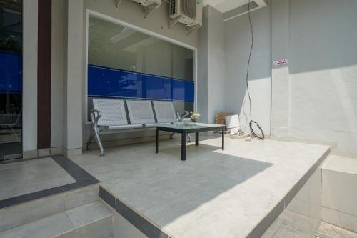 a patio with a table and benches on a building at RedDoorz Plus near Palembang Airport 3 in Palembang