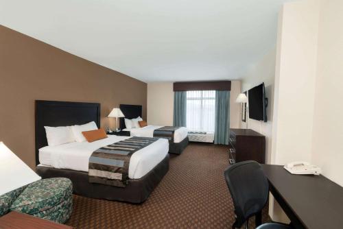 a hotel room with two beds and a desk at Wingate by Wyndham (Lexington, VA) in Lexington