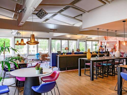 a restaurant with tables and chairs and a bar at Novotel Dijon Sud in Marsannay-la-Côte