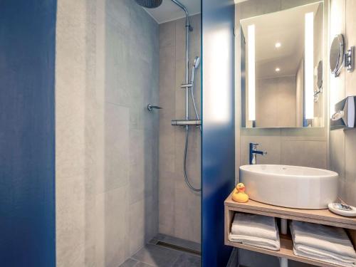a bathroom with a sink and a shower at Mercure Budapest Castle Hill in Budapest