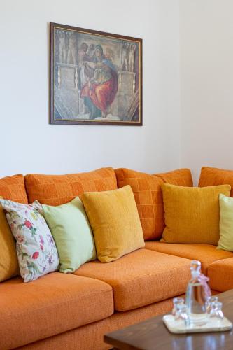 an orange couch in a living room with a painting on the wall at Villa Aiolos in Palekastron