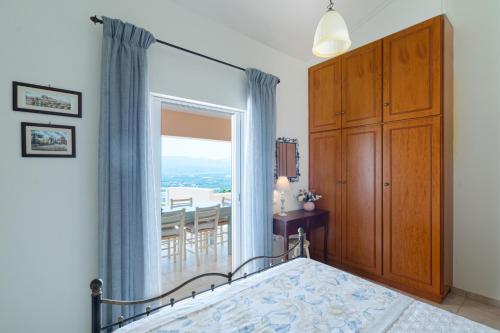 a bedroom with a bed and a large window at Villa Aiolos in Palekastron