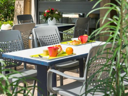 a blue table with two plates of fruit on it at IBIS Budget Aix en Provence Est Le Canet in Meyreuil