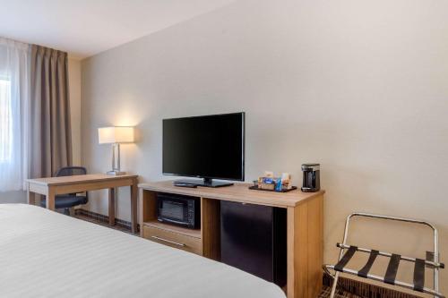 クラーレンビルにあるQuality Hotelのベッドと薄型テレビがあるホテルの部屋