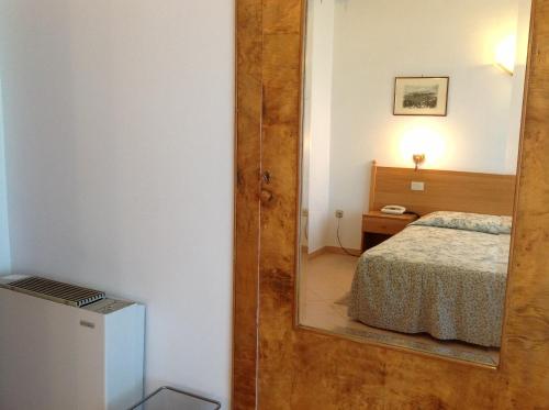 a mirror in a room with a bed and a bedroom at Hotel Castello in Mesagne