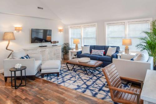a living room with a blue couch and a tv at Edgar Hotel Martha's Vineyard, an Ascend Collection Hotel in Edgartown