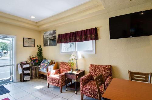 a waiting room with chairs and a table and a tv at Econo Lodge by Choice - Cape Cod in West Yarmouth