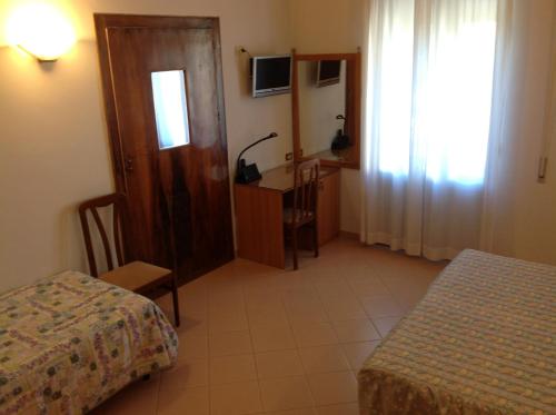 a bedroom with a bed and a desk and a window at Hotel Castello in Mesagne