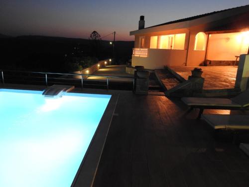 a swimming pool on the roof of a house at night at Villa Aiolos in Palekastron
