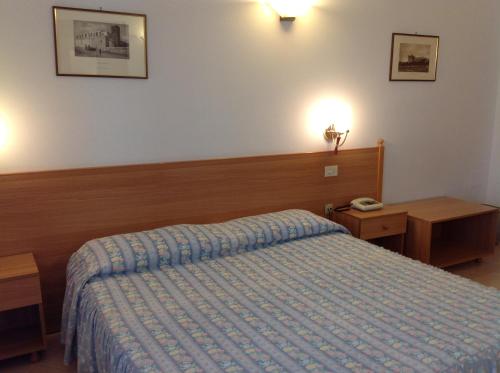 a bedroom with a bed with a blue comforter at Hotel Castello in Mesagne