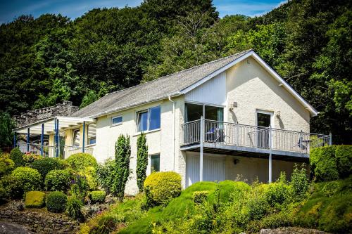a large white house with a balcony and bushes at Netherwood Hotel & Spa in Grange Over Sands