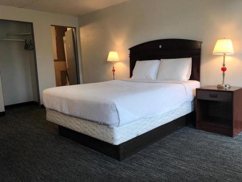 uma cama grande num quarto de hotel com duas lâmpadas em Portland Super Value Inn em Portland