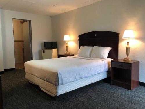 a hotel room with a large bed with two lamps at Portland Super Value Inn in Portland