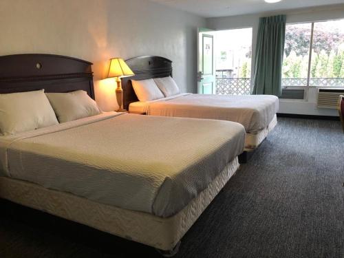 ein Hotelzimmer mit 2 Betten und einem Fenster in der Unterkunft Portland Super Value Inn in Portland