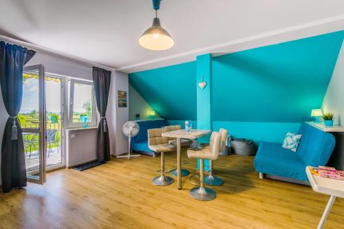 a living room with blue walls and a table and chairs at Verona in Kąty Rybackie
