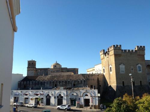 a castle with cars parked in front of it at Hotel Castello in Mesagne