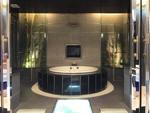 a bathroom with a tub with a tv on the wall at Kai-Hong Motel in Longtan