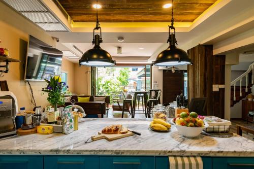a kitchen with a table with a bowl of fruit on it at Maneeya Park Residence in Bangkok