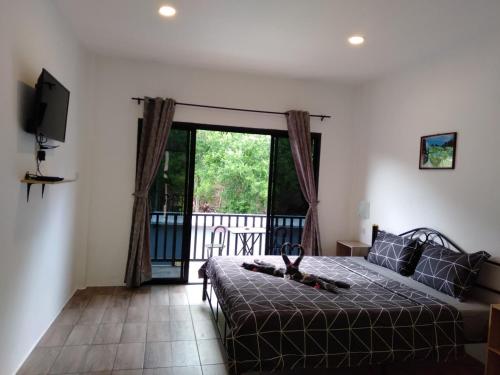 een slaapkamer met een bed en een balkon met een televisie bij Samui Hills in Taling Ngam Beach