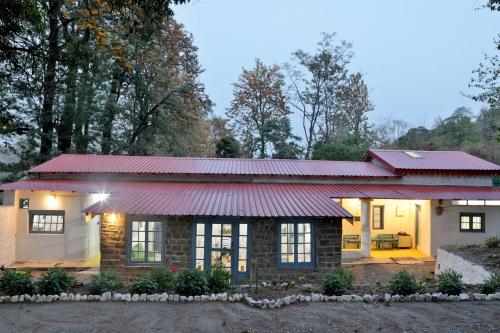 una pequeña casa con techo rojo en The Vergomont - A heritage homestay near Nainital en Nainital