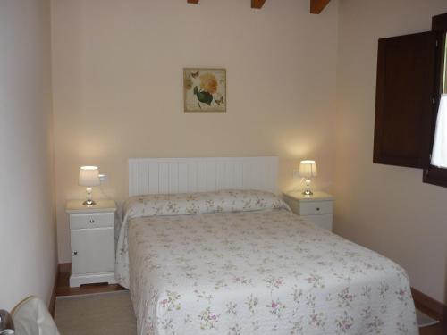 1 dormitorio con 1 cama y 2 mesitas de noche con lámparas en Casa El Campo Mateo, en Peruyes