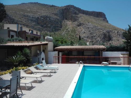 a resort with a swimming pool and mountains in the background at Villa Giulia Tonnara di Bonagia in Valderice